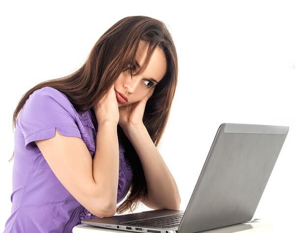 A women overwhelmed whilst looking at a complicated website in English